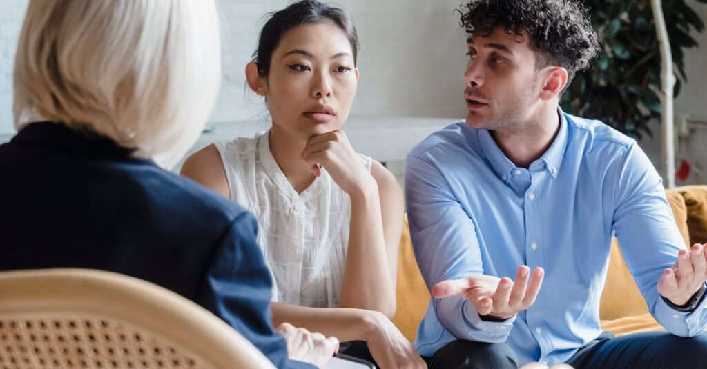 A couple discusses issues with a therapist in a modern office setting.